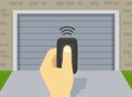 Close-up of hand holding garage door opener. Remote controller opens the door. Outdoor view. Royalty Free Stock Photo