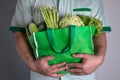 close up hand holding green grocery bag of mixed the organic green vegetables , healthy organic green food shopping and diet heal Royalty Free Stock Photo