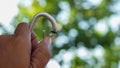 Close up hand holding the key chain with a background of leaves Royalty Free Stock Photo