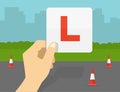 Close-up of hand holding a learner\'s plate. Car driving practicing. Royalty Free Stock Photo