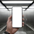 Hand Holding Smartphone with Blank White Screen in Modern Elevator Royalty Free Stock Photo