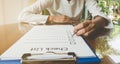 hand holding pen on check list paper And the format for filling in information in business concept Royalty Free Stock Photo