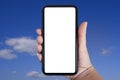 Close-up hand holding phone vertical, Using smart phone towards blue sky background - copy space Royalty Free Stock Photo