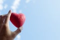 Close up Hand holding the red decorative heart against the blue sky Royalty Free Stock Photo