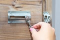 Close up of hand holding security door chain on wooden door Royalty Free Stock Photo