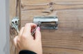 Close up of hand holding security door chain on wooden door Royalty Free Stock Photo