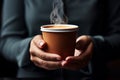 Close up Hand holding a steaming coffee cup