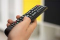 Close up of a hand holding a television remote control. Selective focus Royalty Free Stock Photo