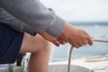 Close up of a hand holding a rope, sheet on a sailboat