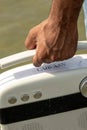 Close-up of a hand holding a white, vintage-style caravan radio.