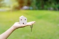 Close-up of hand holding wooden house model and key with green natural Royalty Free Stock Photo