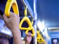 Close-up hand holding yellow handle in the bus Royalty Free Stock Photo