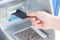 Close up hand inserting card into ATM.