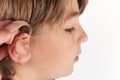 Close up of a hand inserting a hearing aid in a boy`s ear Royalty Free Stock Photo