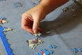 Close up of a hand inserting a piece of jigsaw puzzle.