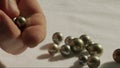 Close up of hand inspecting black Tahitian pearls.