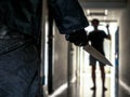 Close up of Hand with knife following young terrified in the apartment. man Bandit is holding a knife in hand, Threat Concept, Royalty Free Stock Photo