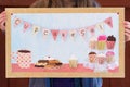 Girl holding up mixed media bake sale poster with cupcakes, cookies, and coffee cup Royalty Free Stock Photo
