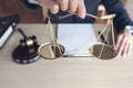 Close up of hand Male lawyer working with scales of justice, gavel and note paper, report the case on wooden table in office, Law Royalty Free Stock Photo