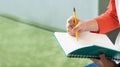 Close up hand of male teenager writing with pencil on notebook a