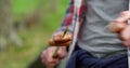 Close up of hand of a man eating food during a camping in autumn