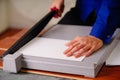 Close up of hand man over the guillotine, working on the guillotine, cutting paper