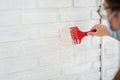 Close up hand of  man painting white color interior wall by paint brush in his house, Renovate house concept Royalty Free Stock Photo