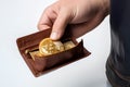 close-up of the hand of a man pulling out a bitcoin from his leather wallet, virtual currency as the future of the economy, white