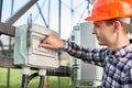 Close up of hand man pushing button at the electrical equipment on solar power station with labeling: enable, disable