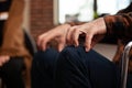 Close up of hand of man sitting in wheelchair at group therapy session Royalty Free Stock Photo