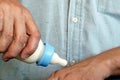 Close up of a hand of man using a milk bottle to testing a hot after mixing to a baby to drinking Royalty Free Stock Photo