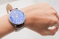 Close up of hand the man wears looking at his analog watch on his hand watching the time on white background, waiting for an