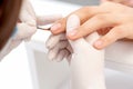 Hand of manicurist applying clear nail polish Royalty Free Stock Photo