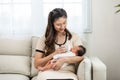 Close up hand of mother holding milk bottle Newborn baby lying on bed drinking milk at warmth place. Cute infant baby feeding milk Royalty Free Stock Photo