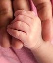 Close up hand of newborn baby holding her mother hand ,lovely moment of family in labour room in hospital.