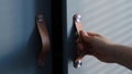 Close up hand open wooden cabinet. shades from blinds on cabinet doors. Royalty Free Stock Photo