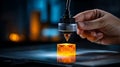 Close up of hand operating a 3d printer nozzle creating a glowing orange cube Royalty Free Stock Photo