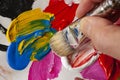 Close up of hand with paintbrush picking blue color