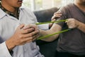 Close up hand patient doing stretching exercise with a flexible exercise band and a physical therapist hand to help in clinic room Royalty Free Stock Photo