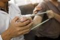 Close up hand patient doing stretching exercise with a flexible exercise band and a physical therapist hand to help in clinic room Royalty Free Stock Photo