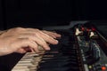 Close-up of hand person playing a piano keyboard in spotlights