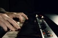 Close-up of hand person playing a piano keyboard in spotlights