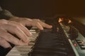 Close-up of hand person playing a piano keyboard in spotlights