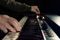 Close-up of hand person playing a piano keyboard in spotlights