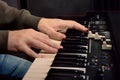 Close-up of hand person playing a piano keyboard in spotlights