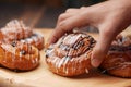 close up hand pick cinnamon danish roll on table Royalty Free Stock Photo