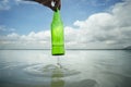 Close up hand picking up glass bottle in the lake Royalty Free Stock Photo