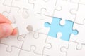 Close up of hand placing the last jigsaw puzzle piece Royalty Free Stock Photo