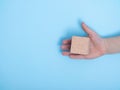 close-up of a hand placing wooden block on a blue background. A child`s hand holds a cube. Royalty Free Stock Photo