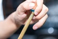 Close up hand player snooker using chalk rubbing a cue